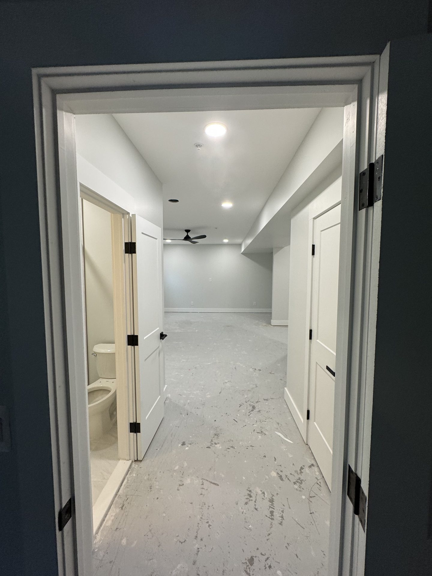 Finished basement hallway with bathroom and bedroom in Grasonville, MD — Assured Contracting Company