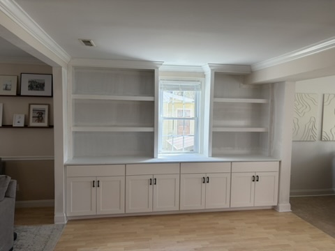 Custom built-in cabinets and shelving around a window in Grasonville, MD — Assured Contracting Company