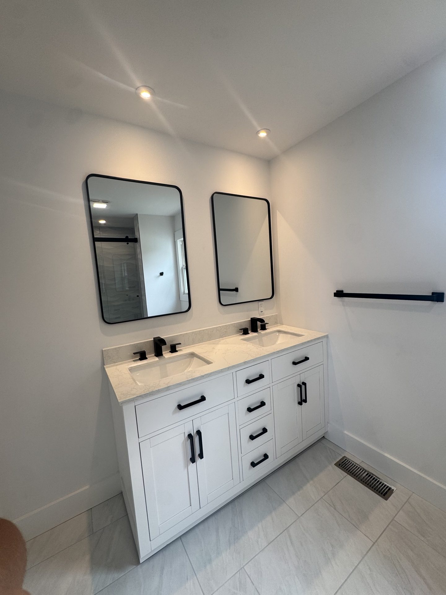 Bathroom remodel with white double vanity and black fixtures in Grasonville, MD — Assured Contracting Company