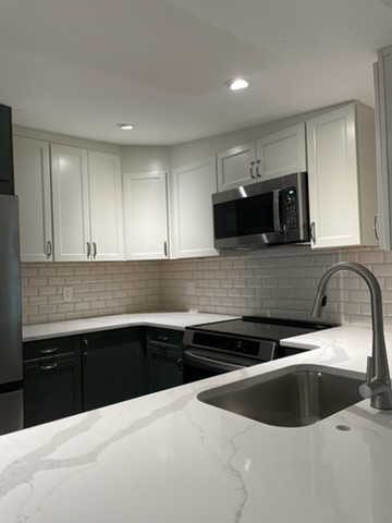 Kitchen remodel with white cabinets, quartz counters and subway tile backsplash in Grasonville, MD — Assured Contracting Company