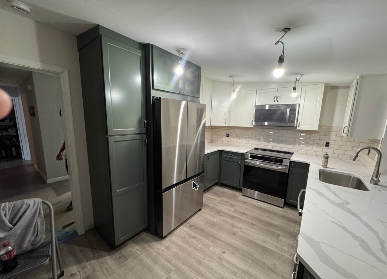 Kitchen remodel with green and white cabinets and quartz counters in Grasonville, MD — Assured Contracting Company
